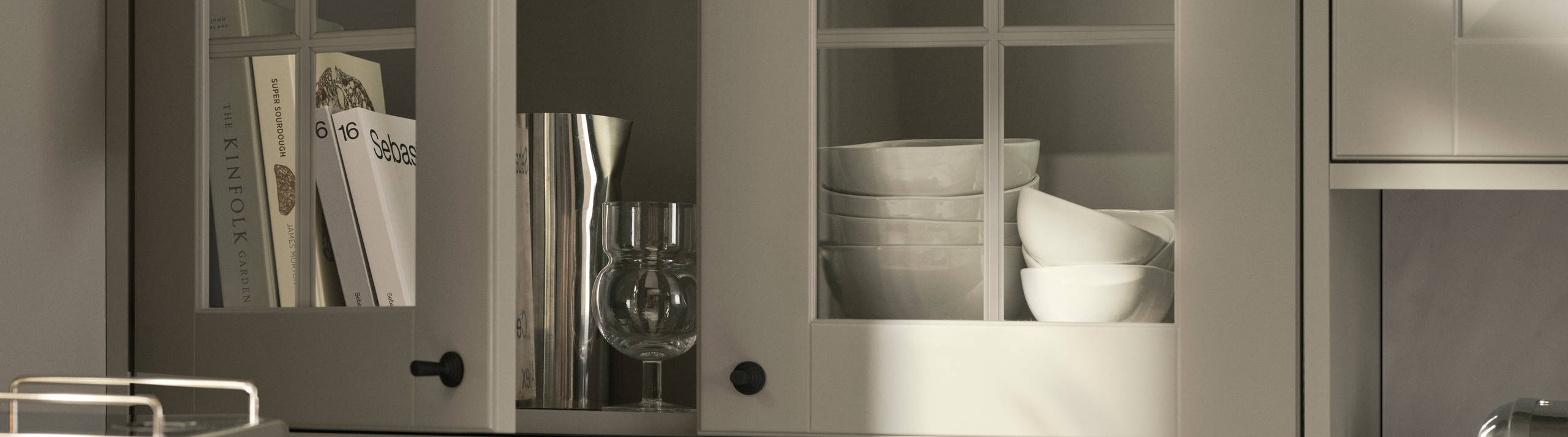 Bänkstående vitrinskåp med lådor.