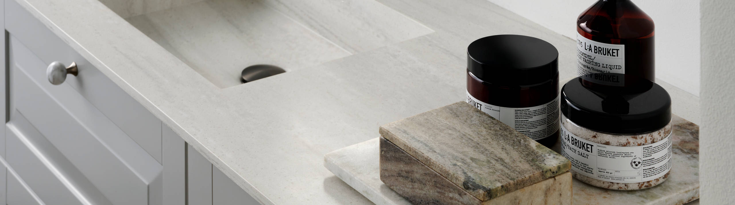 Nærbillede af sort armatur i romantisk badeværelse Nordic i lys grå farve Sky fra INVITA med klassiske detaljer som fyldniner og glaslåger med sprosser, marmor håndtag