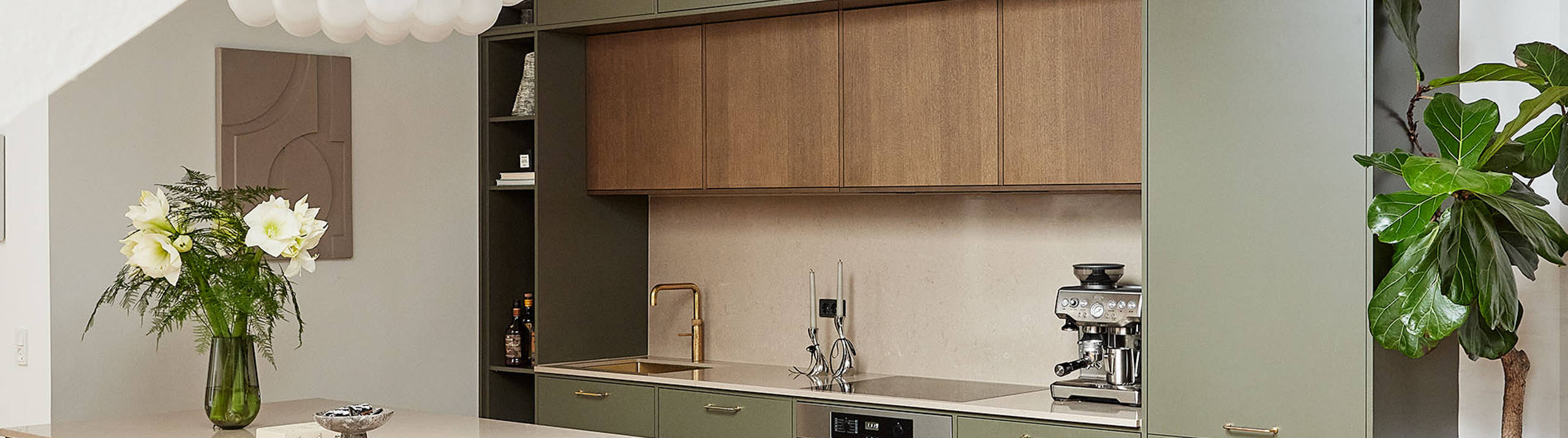 Grønt køkken med træskabe og køkkenø