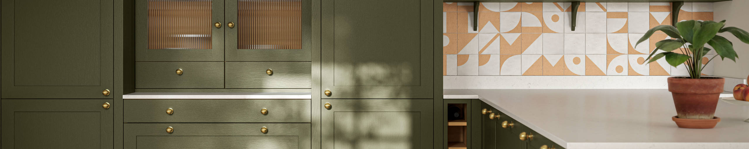 Premium Shaker kitchen Wardley Tailored green with kitchen island, traditional detailing, brass accessories, white worktop and Classic Flint Grey oiled oak engineered wood flooring.