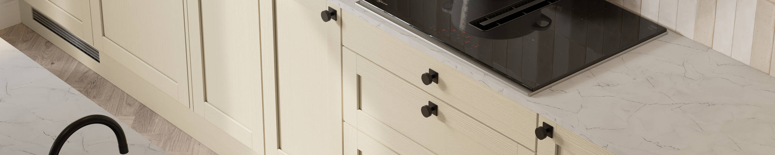 View from above of contemporary Shaker kitchen Ambleside from Magnet in neutral shade Sand with black sink and tap in kitchen island, induction hob with extractor, marbled worktop and black knobs.
