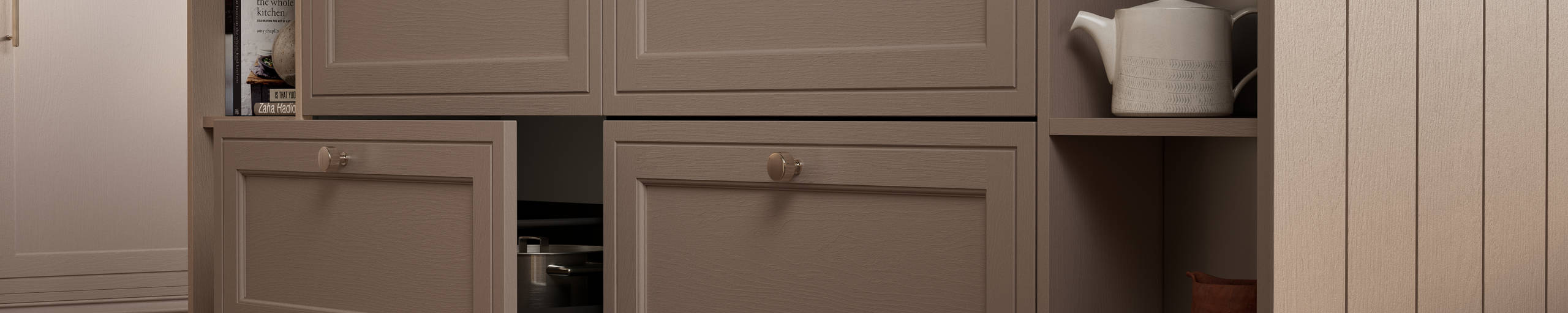 Close-up view of Shaker style painted wood grain Bewdley cabinet kitchen island with classic design steel knobs, open shelves and decorative splinth matching the Cornish Clay shade.
