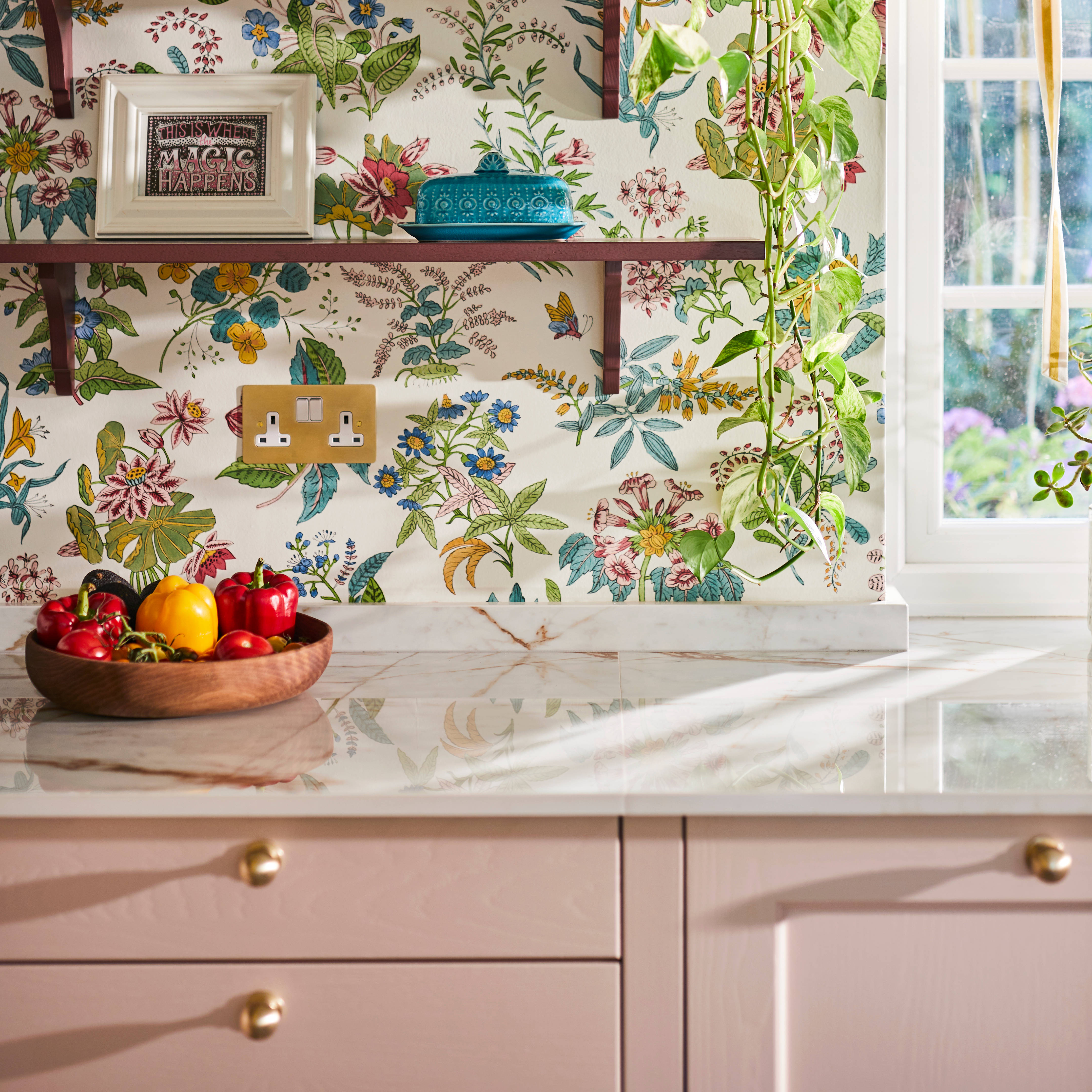 Colourful floral wallpaper, burgundy colour open shelves with colourful decorations over Ludlow Chalk blush cabinets.