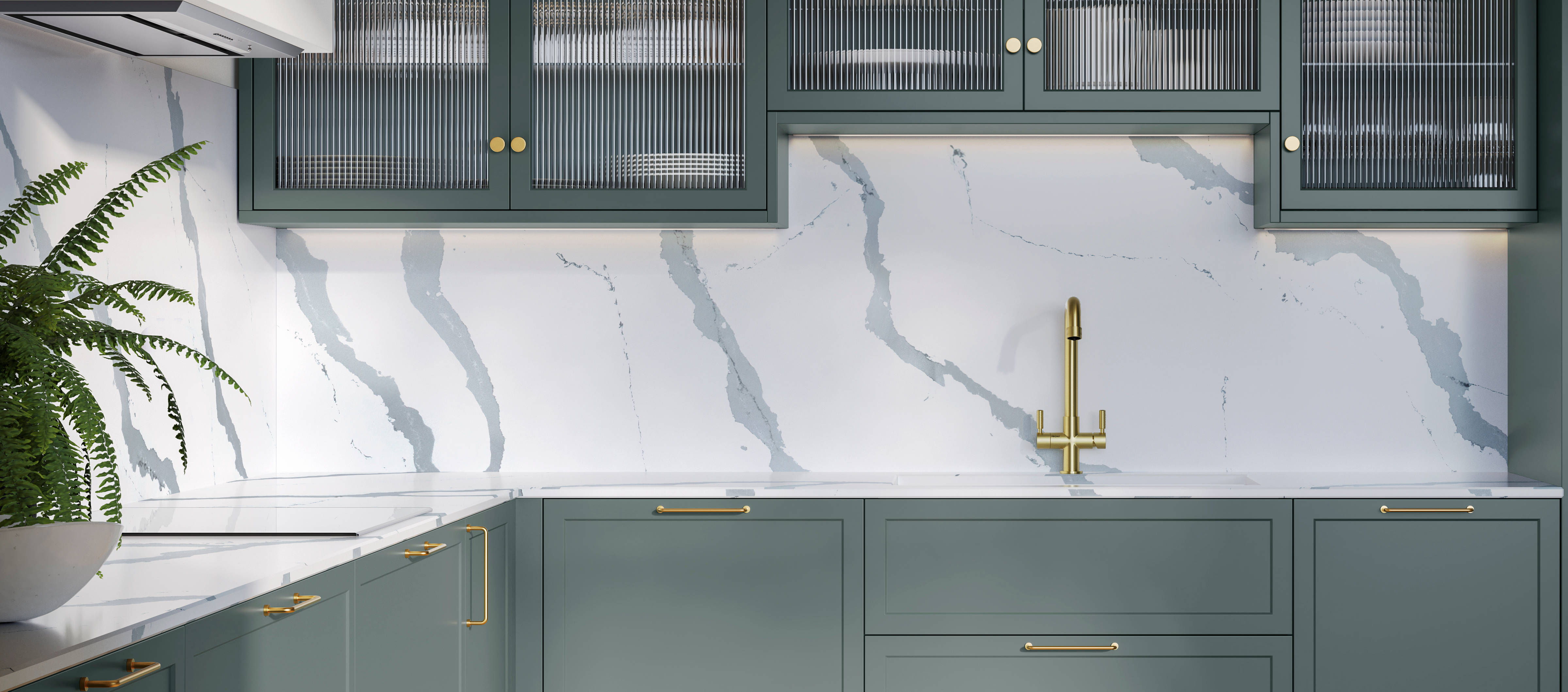 Modern Shaker kitchen Brunswick Spruce, a muted green shade, wall cabinets with fluted glass doors, Quartz Bianco Calacatta worktop and splashback, brass accessories like knobs, handles and tap, and a light wood herringbone floor.