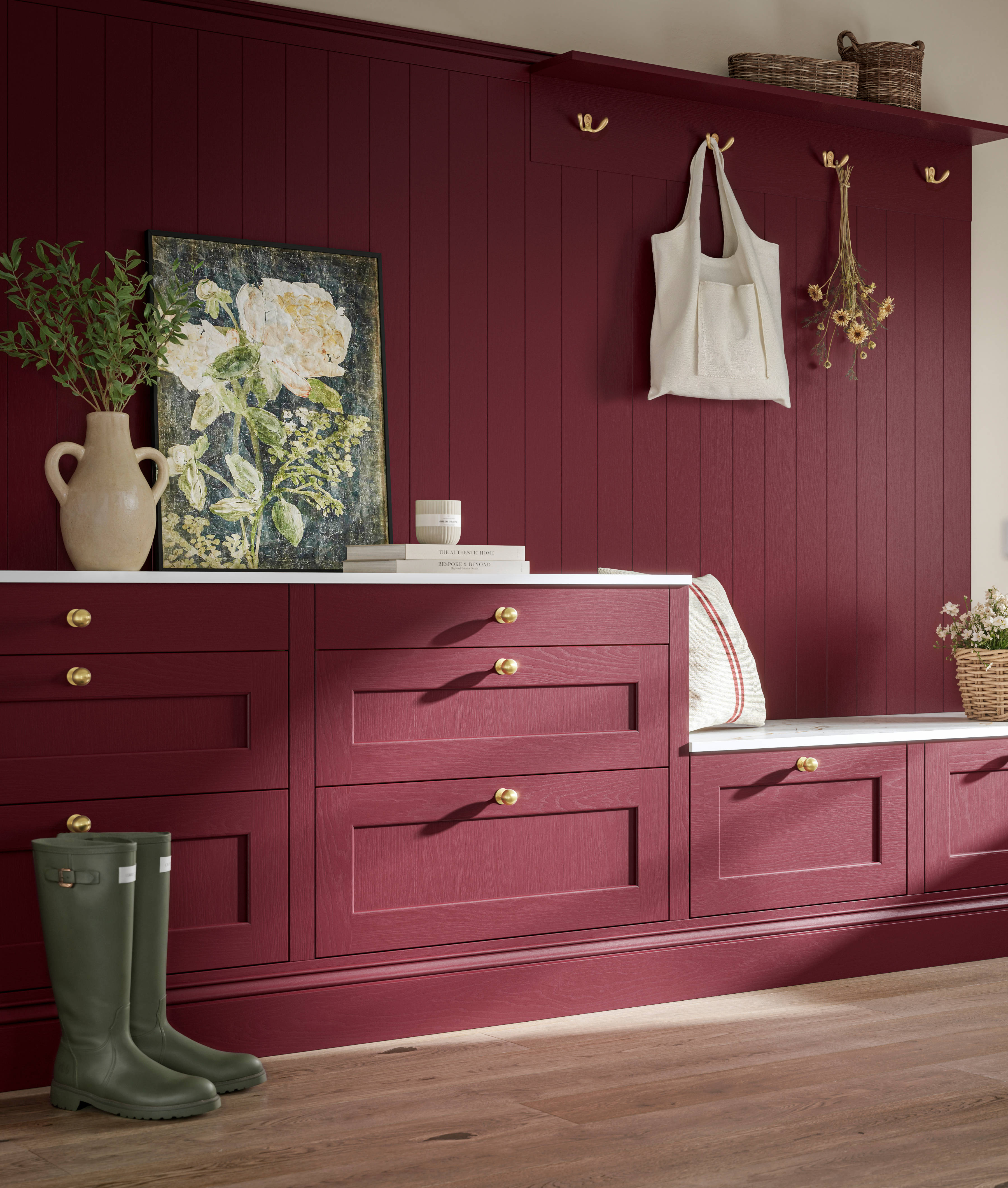 Traditional Shaker-style tactile woodgrain Ludlow kitchen bootroom space in bold shade Morello, brass accents and dusty oak vinyl flooring with Ludlow parchment kitchen island in foreground.