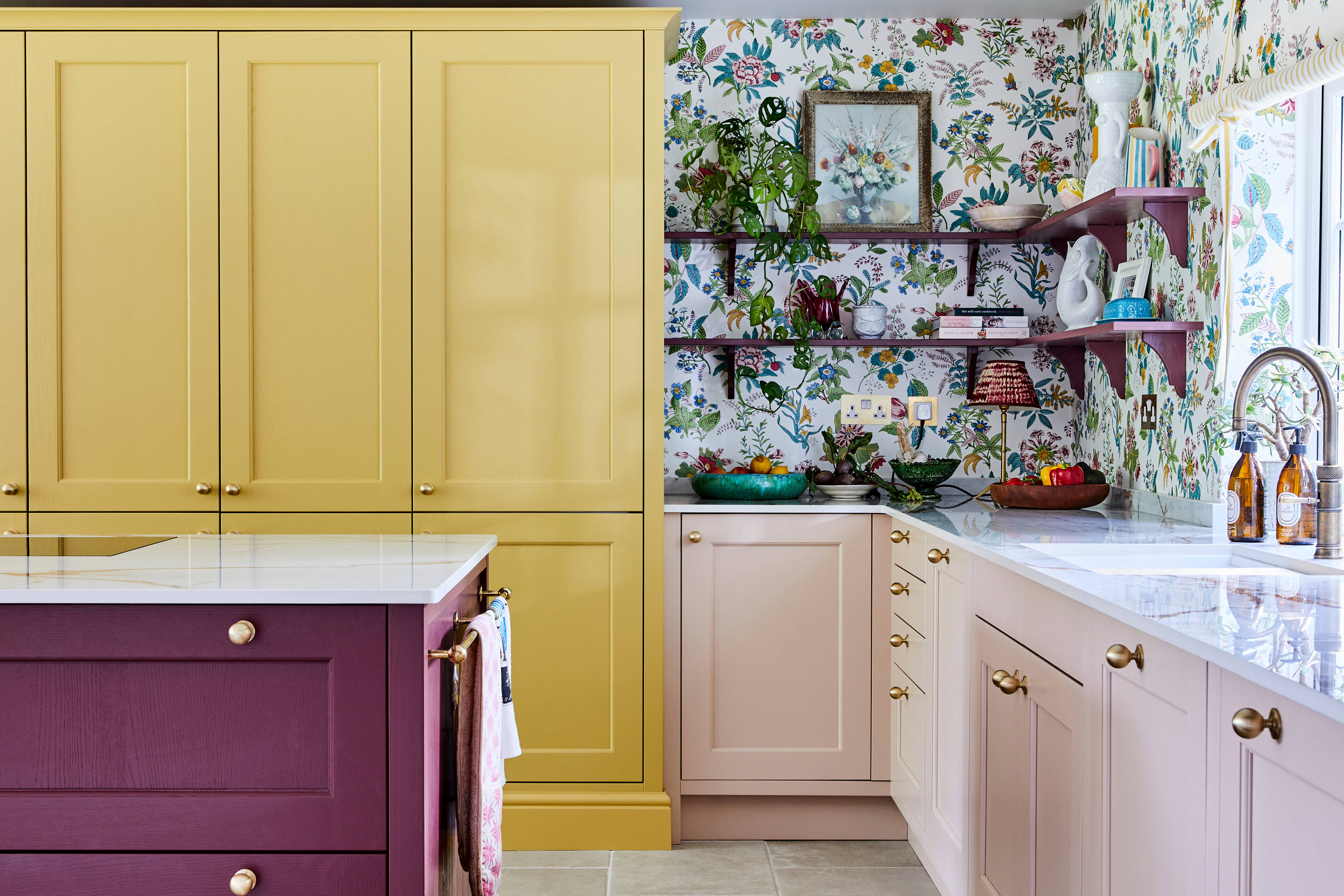 Wide image of sink, kitchen island and pantry larder. Ludlow cabinetry from Magnet in colours Burlington Red, Chalk blush and Harvest in Heritage classic with a contemporary twist.