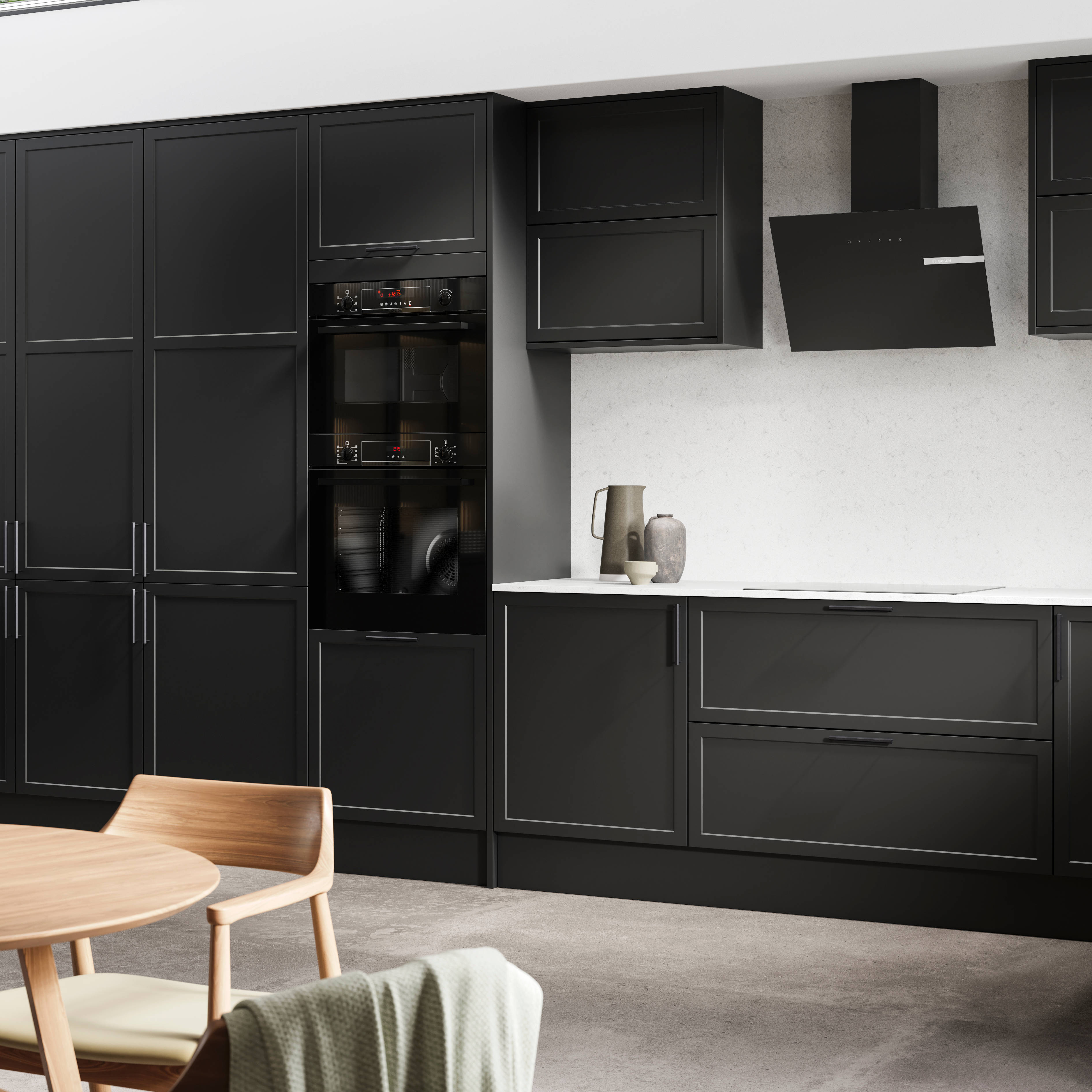 View of modern shaker kitchen Brunswick Sumi Black, with screen extractor over induction hob, tall fluted glass doorsvitrine cabinets, black frame skylights with wood dining table and chairs in foreground.