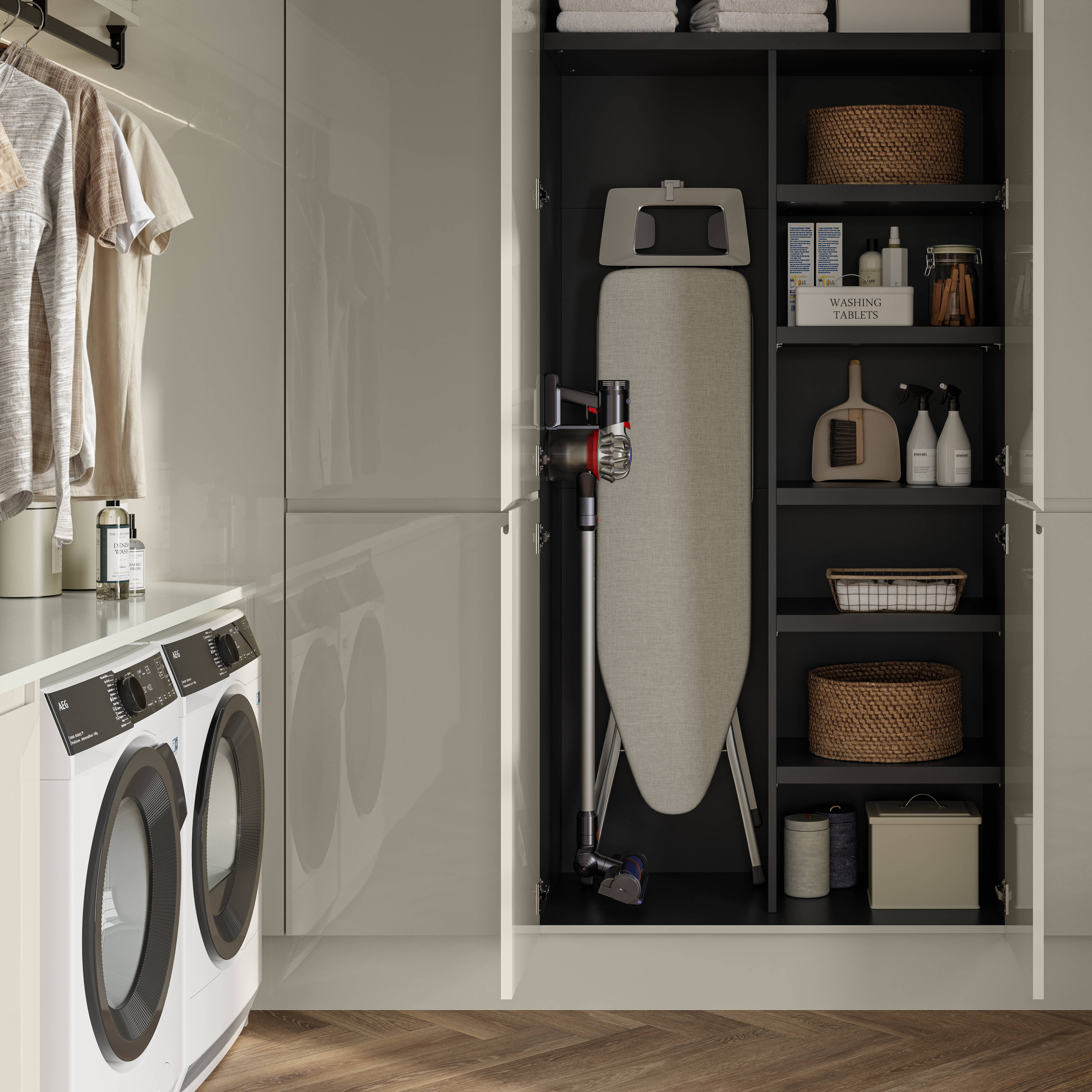Luna Gloss Limestone utility room with tall cabinets, opened cabinets showing storage of Ironing board and laundry detergents, Amtico smouldered oak in parquet flooring.
