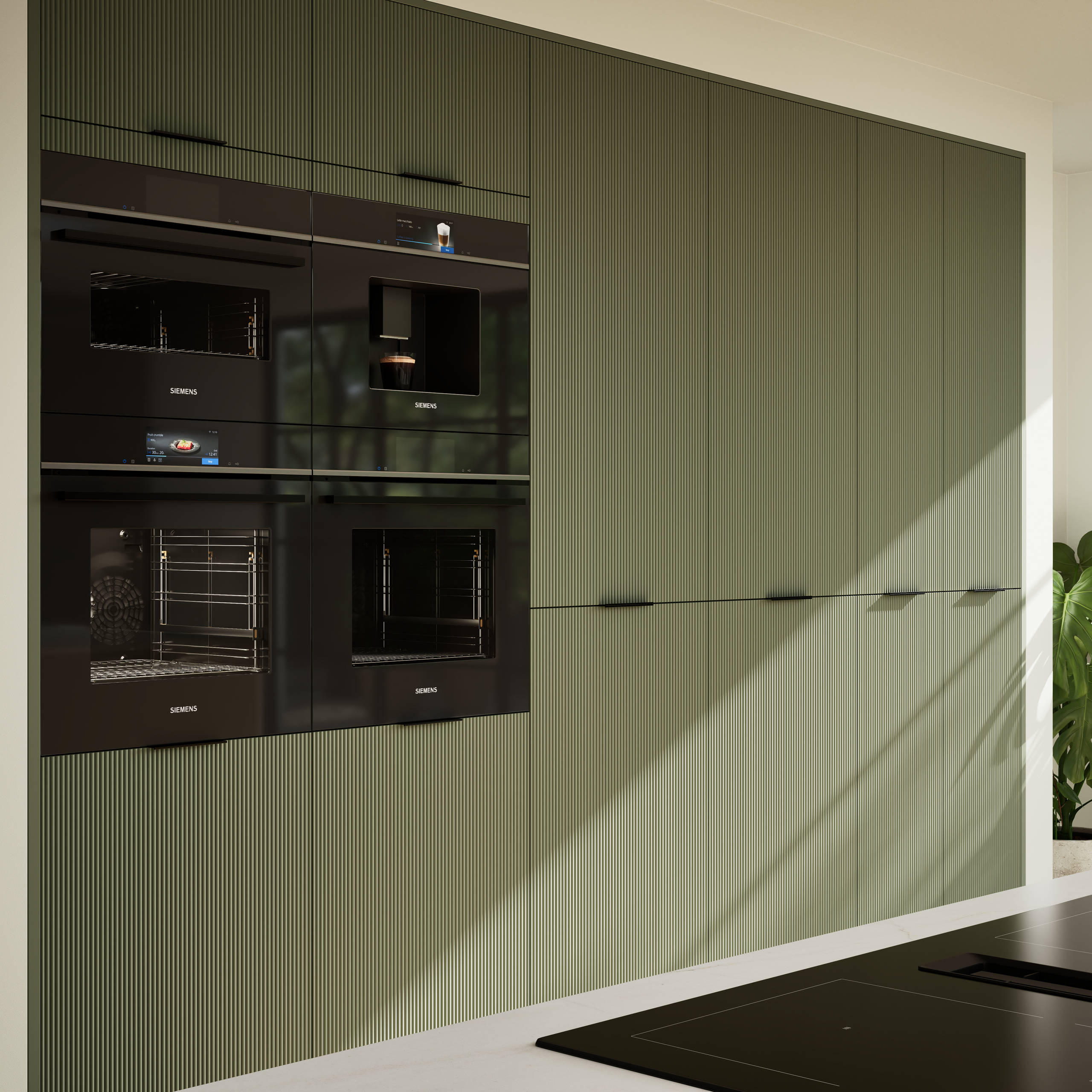 Green fluted kitchen fronts on tall cabinets with built-in appliances and black handles.