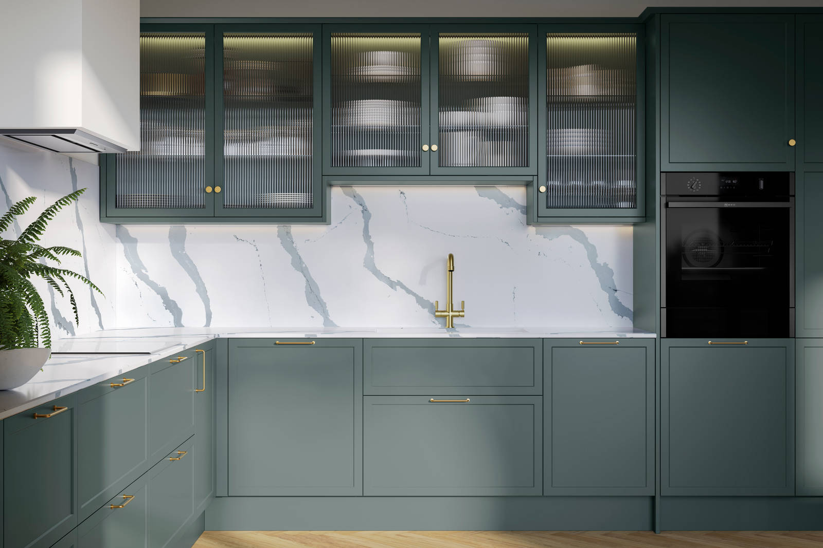 Modern Shaker kitchen Brunswick Spruce, a muted green shade, wall cabinets with fluted glass doors, Quartz Bianco Calacatta worktop and splashback, brass accessories like knobs, handles and tap, and a light wood herringbone floor.