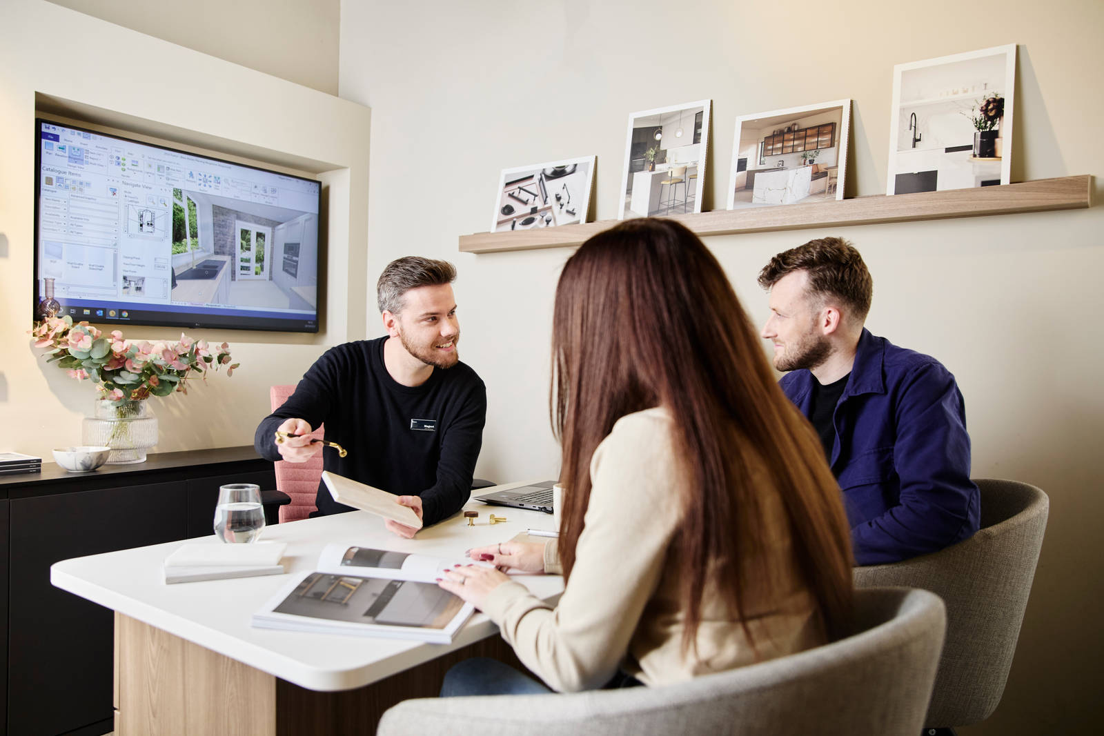 Magnet kitchen designer showing samples to customers in a Magnet store during consultation, woman browsing a brochure.