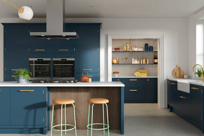 Full view of Soho Voyage Blue kitchen with kitchen island section for seating, with fluted wood panel.