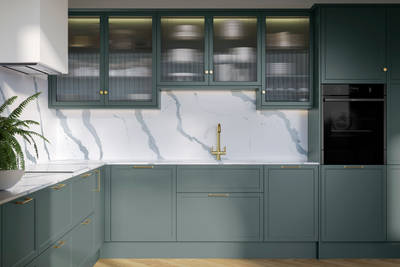 Modern Shaker kitchen Brunswick Spruce, a muted green shade, wall cabinets with fluted glass doors, Quartz Bianco Calacatta worktop and splashback, brass accessories like knobs, handles and tap, and a light wood herringbone floor.