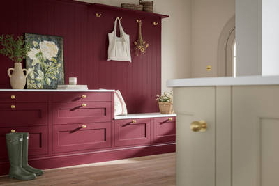 Traditional Shaker-style tactile woodgrain Ludlow kitchen bootroom space in bold shade Morello, brass accents and dusty oak vinyl flooring with Ludlow parchment kitchen island in foreground.