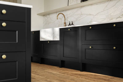 Traditional Shaker-style tactile woodgrain Ludlow Sumi Black kitchen with brass knobs, brass tap and white ceramic sink, white and grey marbled splashback and Amtico oak stripwood vinyl flooring.