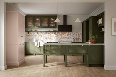 Premium Shaker kitchen Wardley Tailored green with traditional detailing, brass accessories, fluted glass wall vitrine cabinets, standalone Wardley Chalk Blush pantry, Classic Flint Grey oiled oak engineered wood flooring.