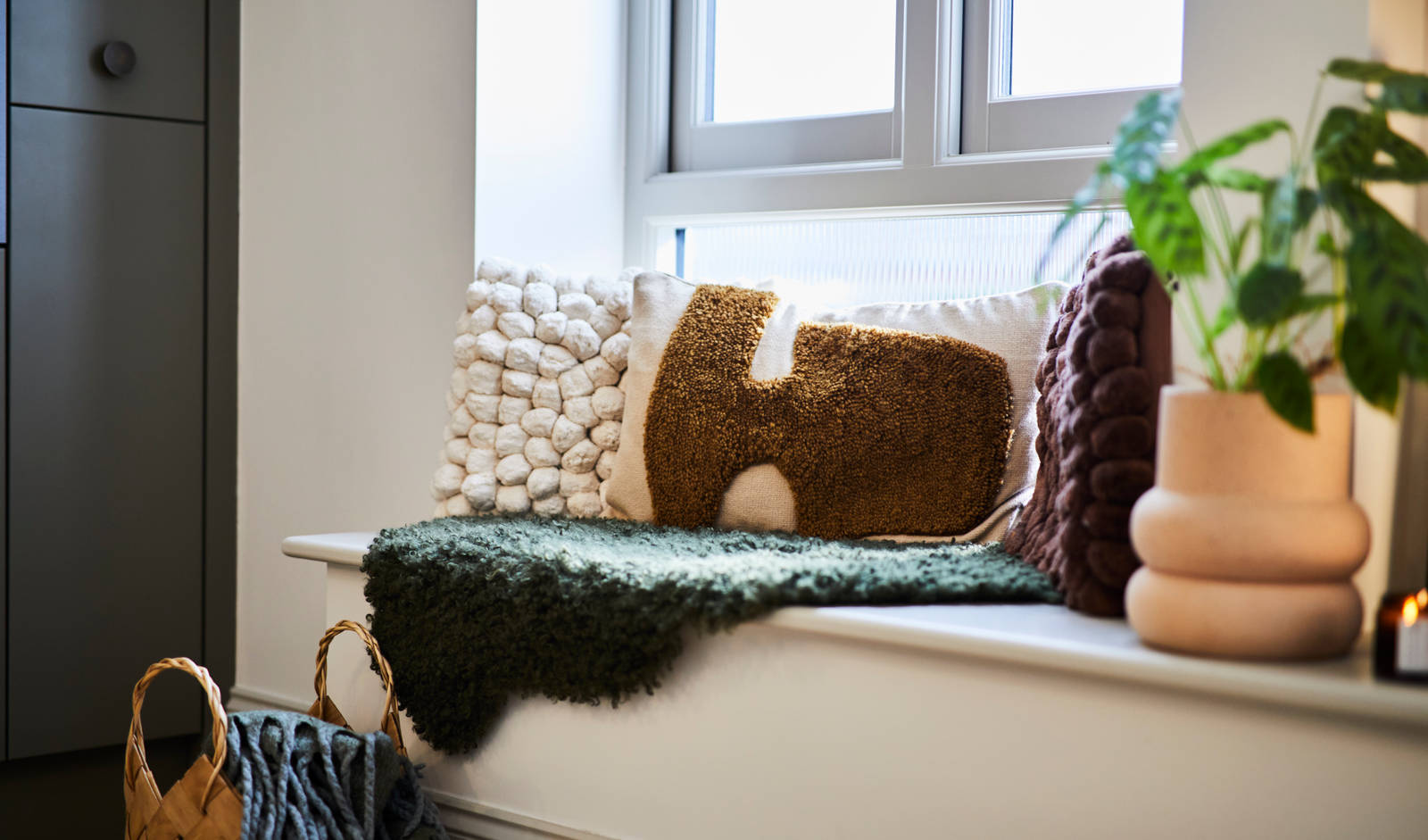 Close-up of seating area on low seating bench with pillows i earth tones